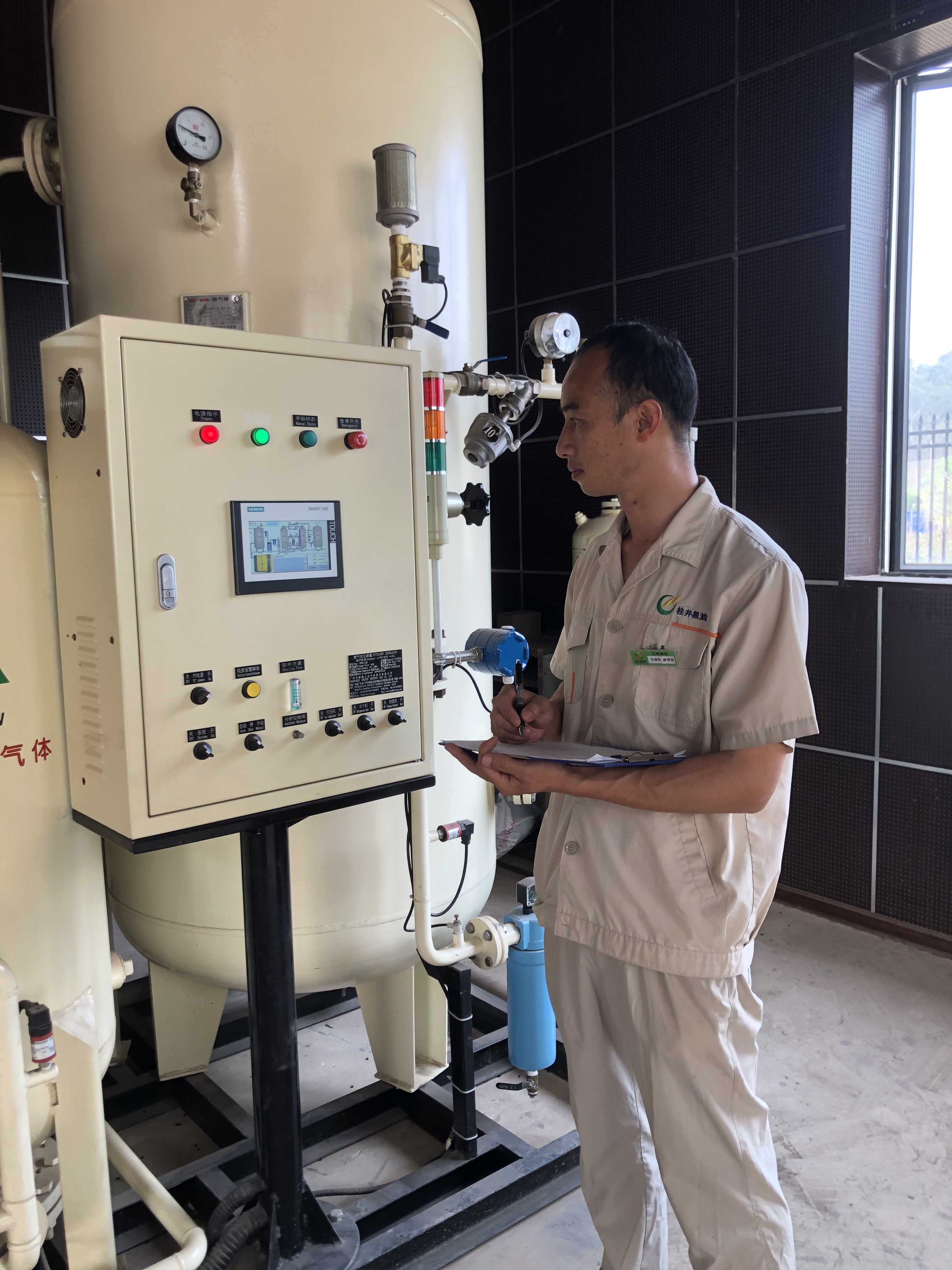 /QJ_870578110410.jpg 粮库工作人员在查看充氮设备罐体分离筛工作情况(摄影:丘荣茂).jpg