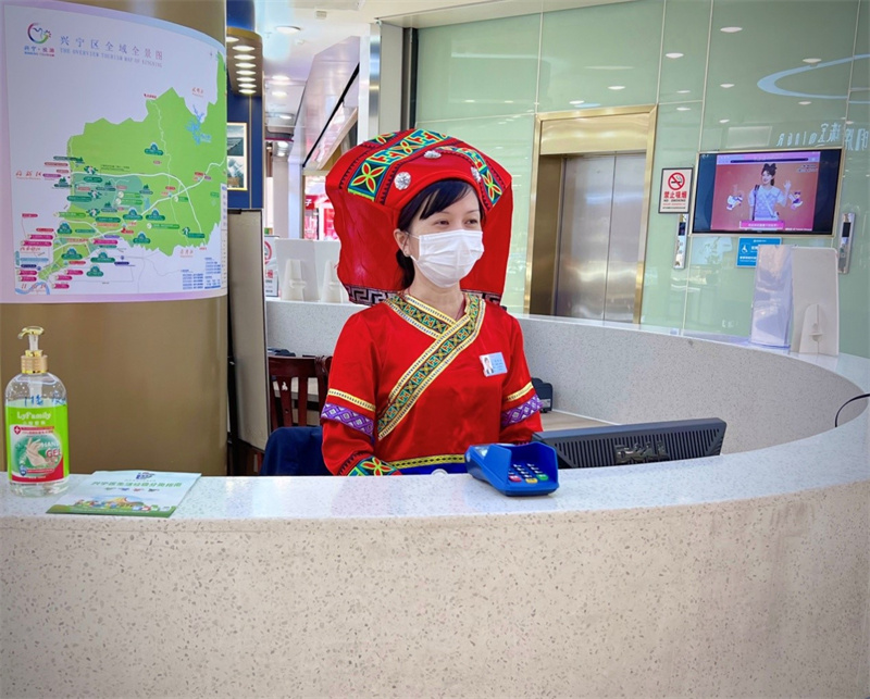 /QJ_981646124215.jpg 百货朝阳店收银员身穿壮族民族服装接待顾客.jpg